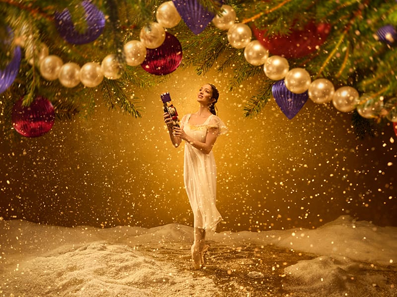 English National Ballet (ENB)'s image of a ballet dancer on pointe holding a toy Nutcracker for The Nutcracker 2024/25